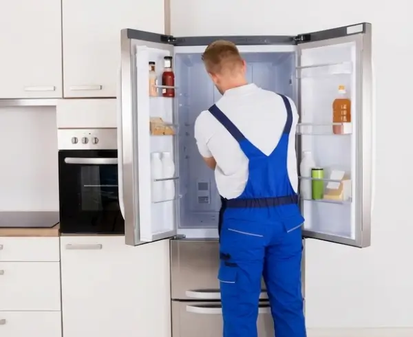 Refrigerator repair technician repairing fridge compressor and cooling system in Bahrain kitchen | emergency refrigerator repair services in Manama, Riffa, Muharraq by Al Anwar Experts